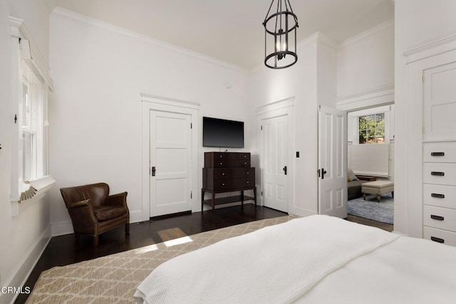 bedroom featuring an inviting chandelier, ornamental molding, and dark hardwood / wood-style floors