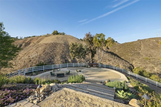 view of property's community featuring fence, a mountain view, and a rural view