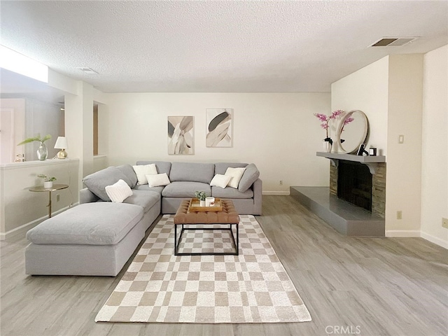 living room with a textured ceiling and light wood-type flooring