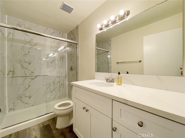 bathroom featuring hardwood / wood-style flooring, vanity, toilet, and an enclosed shower