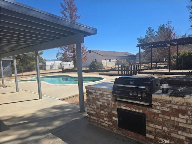 view of swimming pool featuring area for grilling, a fenced backyard, exterior kitchen, a patio area, and a pergola