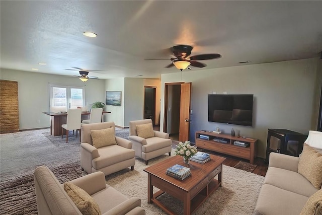 carpeted living room featuring a ceiling fan and baseboards