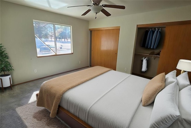 bedroom with baseboards, carpet flooring, a ceiling fan, and multiple closets