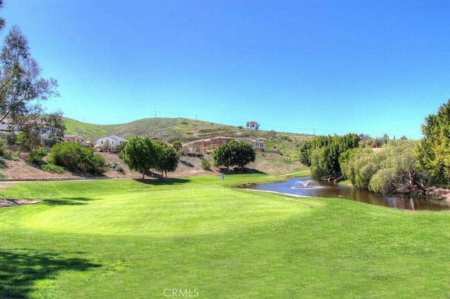 view of community featuring a water and mountain view and a yard