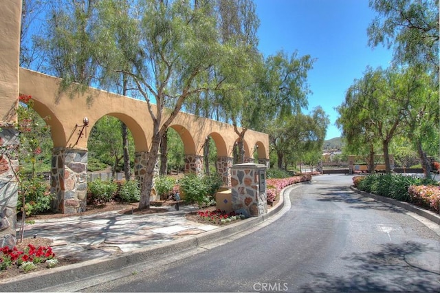 view of road with curbs and a gated entry