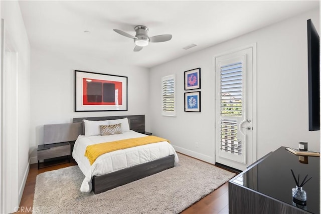 bedroom featuring baseboards, visible vents, a ceiling fan, wood finished floors, and access to exterior