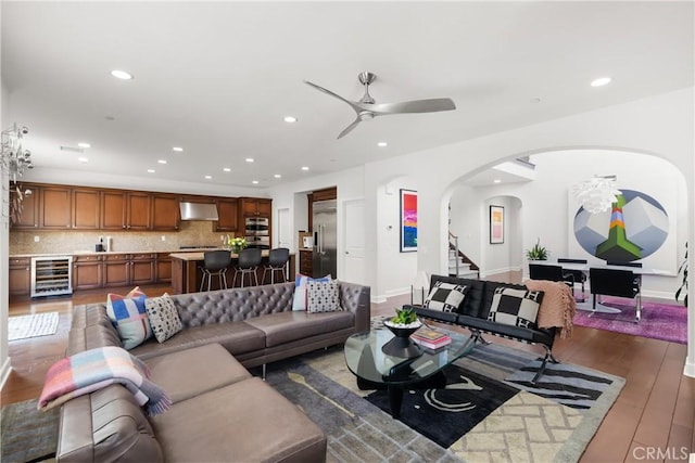 living room with ceiling fan, beverage cooler, and dark hardwood / wood-style flooring