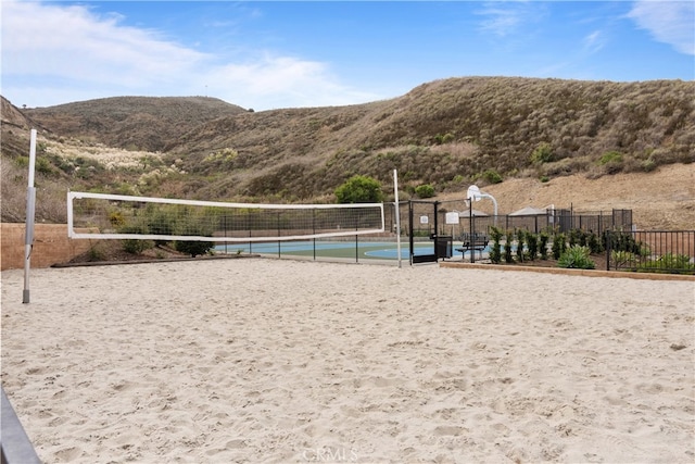 view of property's community with volleyball court, fence, and a mountain view