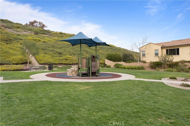 view of property's community with playground community and a lawn