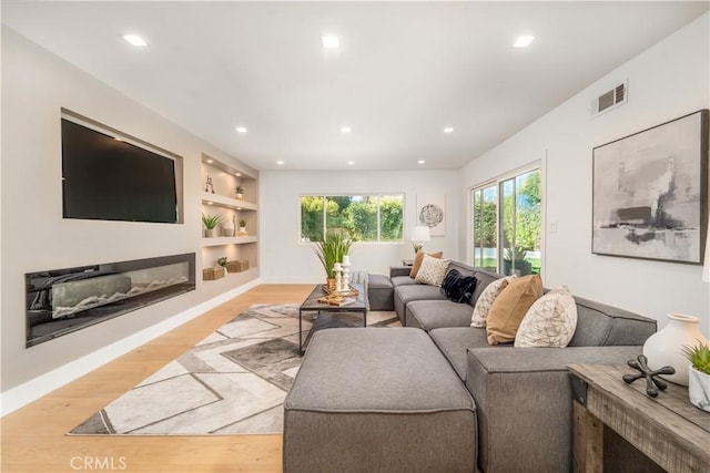 living room featuring light hardwood / wood-style flooring and built in features