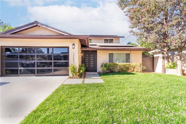 view of front of house featuring a garage, a front yard, and solar panels