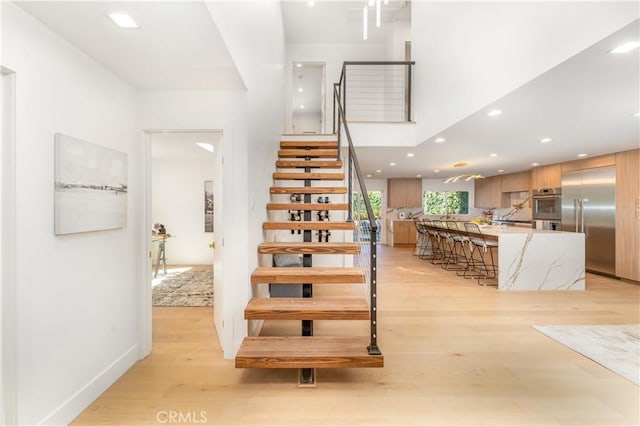 stairway featuring wood-type flooring and a high ceiling