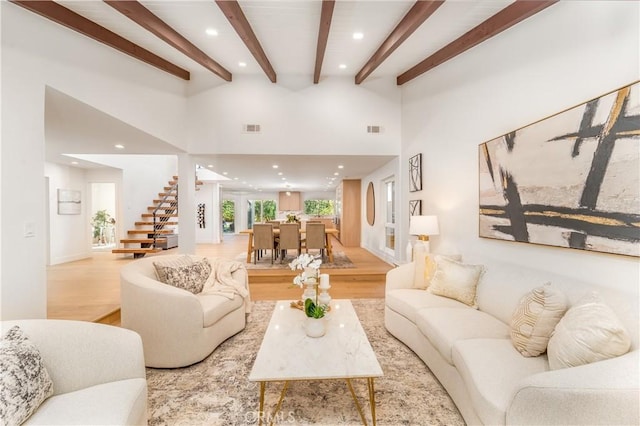 living room featuring light wood-type flooring and beam ceiling