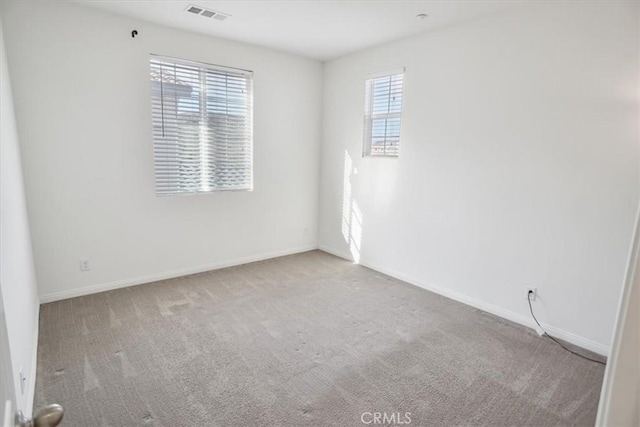 spare room featuring light colored carpet