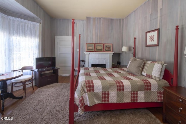 bedroom with a fireplace and hardwood / wood-style floors