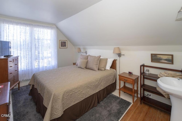 bedroom with vaulted ceiling and hardwood / wood-style floors