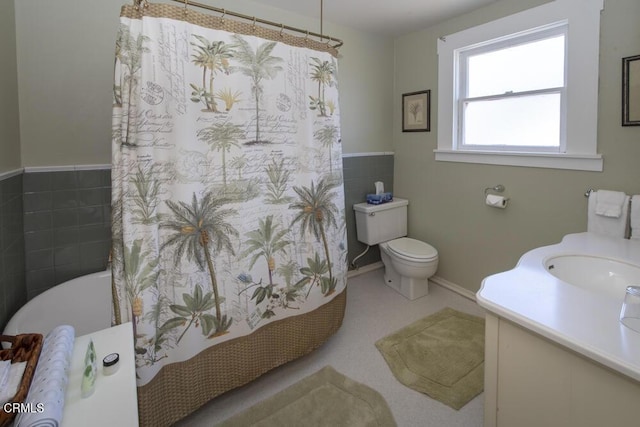 bathroom featuring vanity, tile walls, and toilet