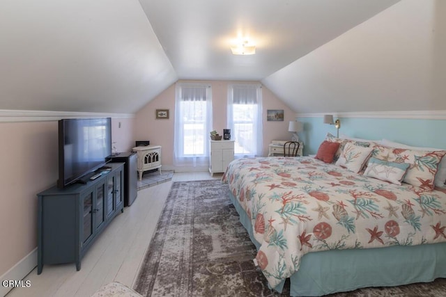 bedroom featuring vaulted ceiling and light wood-type flooring