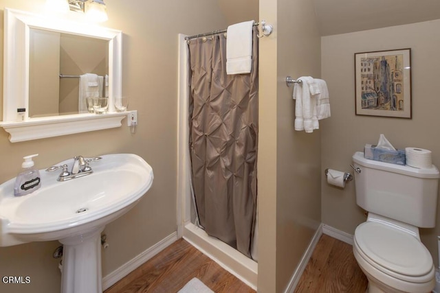 bathroom with hardwood / wood-style flooring and toilet