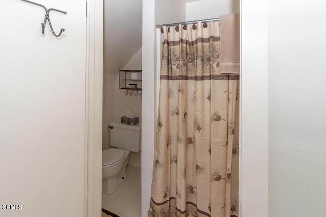 bathroom with curtained shower, tile patterned floors, and toilet