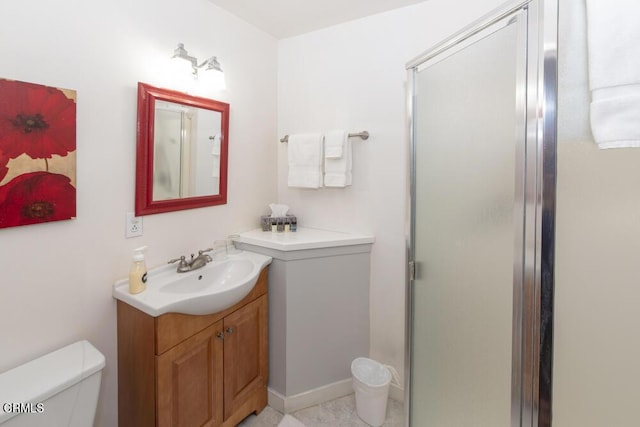 bathroom featuring vanity, toilet, and a shower with shower door