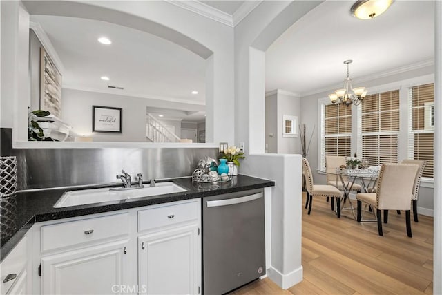 kitchen featuring dishwasher, sink, white cabinets, and decorative light fixtures