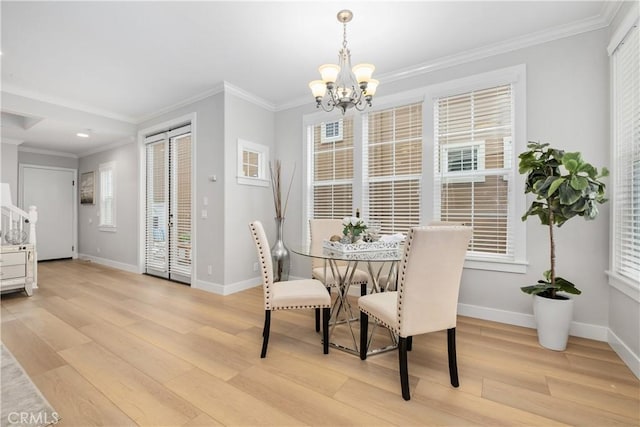 dining space featuring an inviting chandelier, crown molding, and light hardwood / wood-style floors