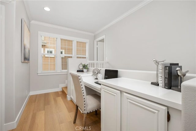 office featuring ornamental molding, built in desk, and light wood-type flooring