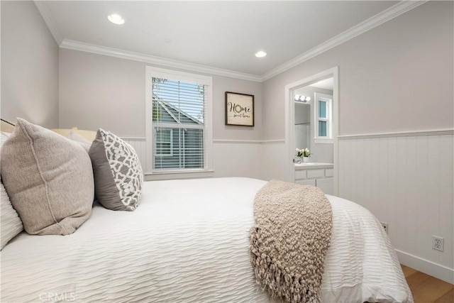 bedroom with ornamental molding, ensuite bathroom, and light hardwood / wood-style flooring