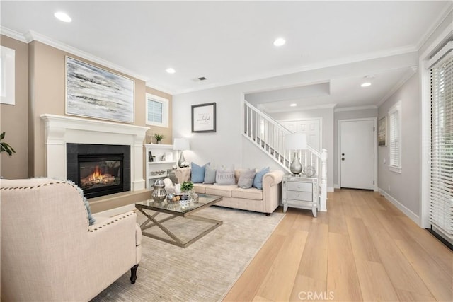 living room with ornamental molding and light hardwood / wood-style flooring