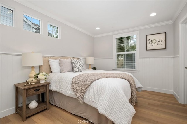 bedroom featuring multiple windows, crown molding, and light wood-type flooring