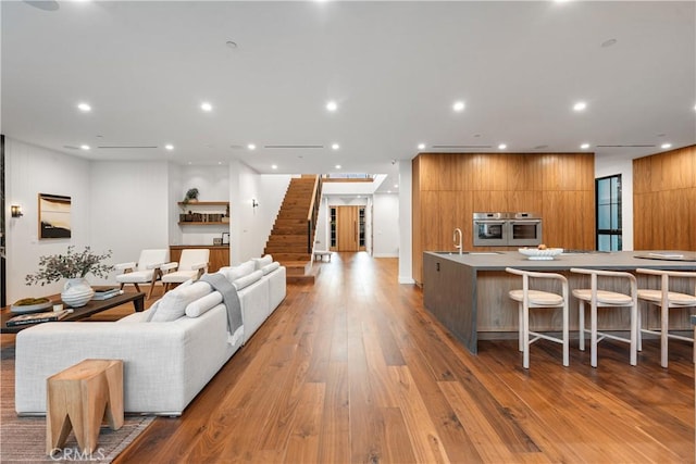 living room with sink and light hardwood / wood-style flooring