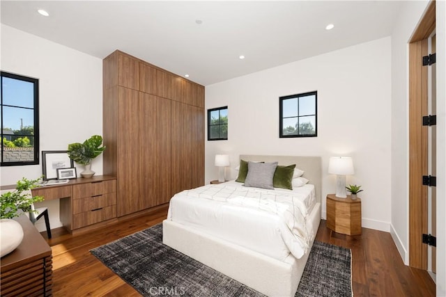 bedroom featuring built in desk and dark hardwood / wood-style floors