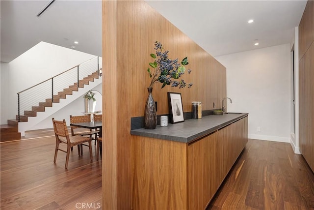 bar featuring hardwood / wood-style floors and sink