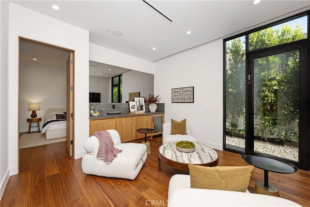 sitting room featuring wood-type flooring and a wall of windows