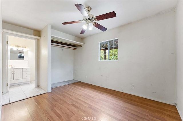 unfurnished bedroom with ceiling fan, ensuite bath, light hardwood / wood-style floors, and a closet