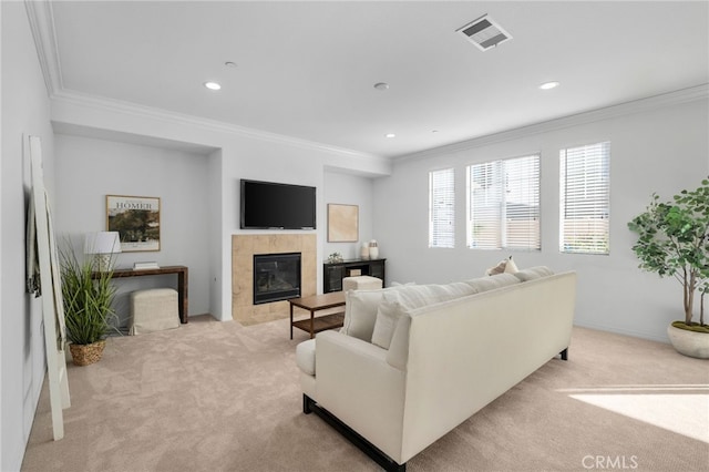 living room featuring light colored carpet, ornamental molding, and a tiled fireplace