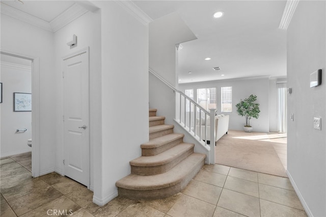 stairway with crown molding and tile patterned flooring