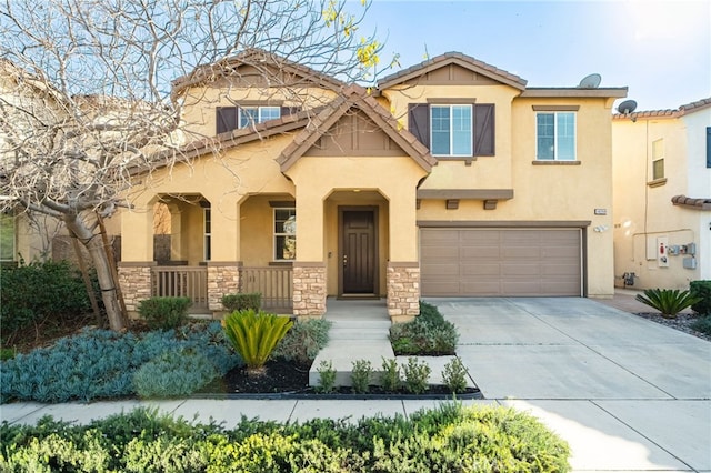 view of front of home with an attached garage, stone siding, concrete driveway, and stucco siding