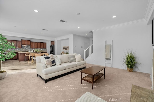 living area with light carpet, stairway, visible vents, and crown molding