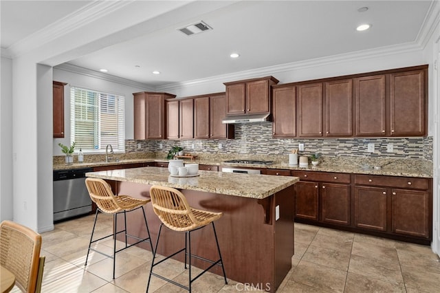 kitchen featuring a center island, visible vents, appliances with stainless steel finishes, light stone countertops, and under cabinet range hood