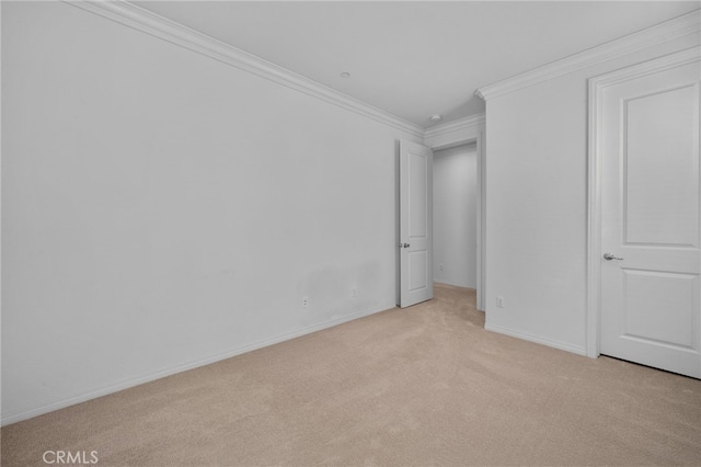 unfurnished bedroom featuring ornamental molding, light colored carpet, and baseboards