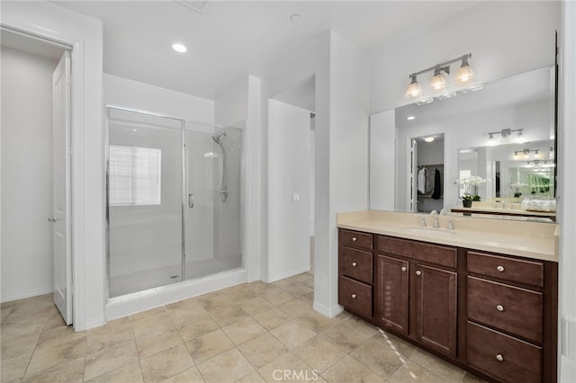 bathroom with vanity and a shower with door