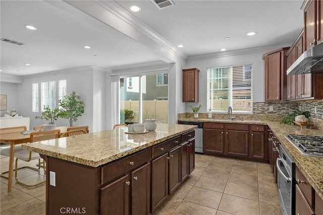 kitchen featuring visible vents, stainless steel appliances, crown molding, and a center island