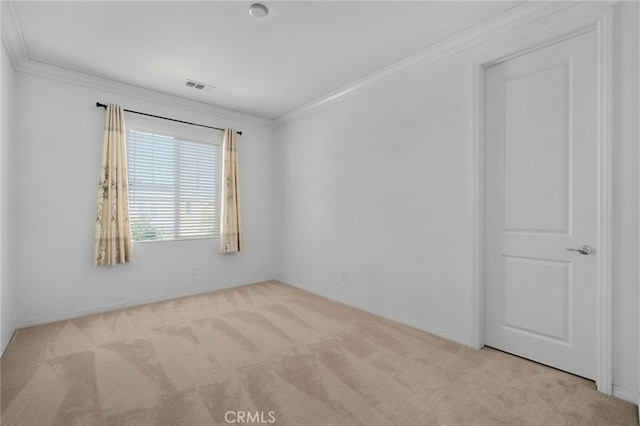 empty room featuring ornamental molding, light colored carpet, visible vents, and baseboards