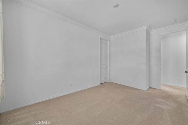 unfurnished room featuring light carpet, baseboards, and crown molding