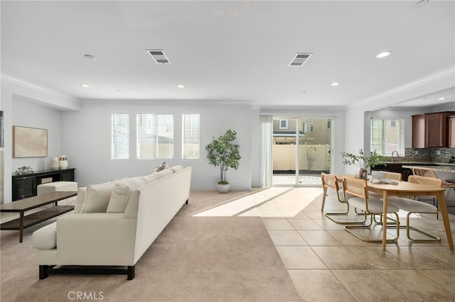 living room with ornamental molding and light tile patterned flooring