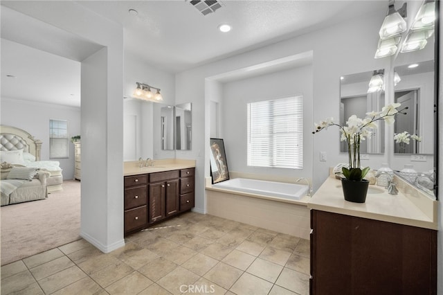 bathroom with vanity, tile patterned flooring, and tiled bath