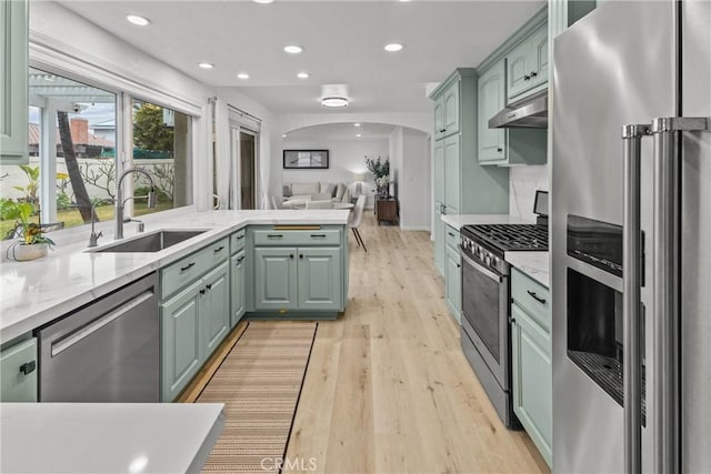 kitchen featuring sink, stainless steel appliances, light hardwood / wood-style floors, and green cabinets