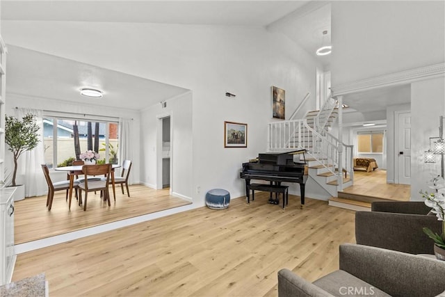 living room with high vaulted ceiling, beam ceiling, and light hardwood / wood-style floors